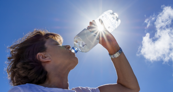 Senior woman staying hydrated by drinking a bottle of water.