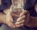 Senior holding a glass of water