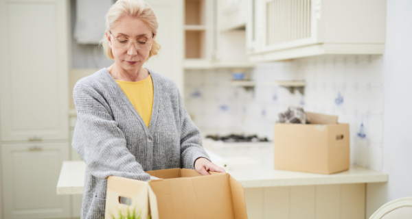 senior woman packing belongings to downsize