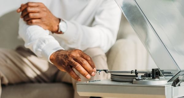 A man setting up a record player for a person with dementia.