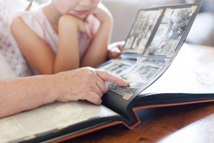 Granddaughter and grandmother look through memory book together