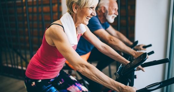 mature couple doing indoor cycling together