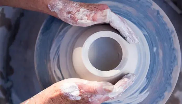 Senior making pottery at a pottery wheel