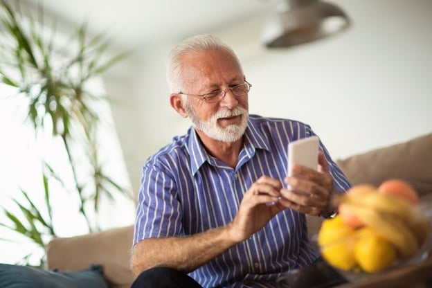 Senior man learns a new language from a phone app