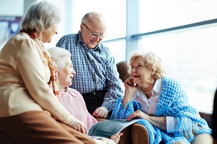 Group of seniors talks together and looks at magazine