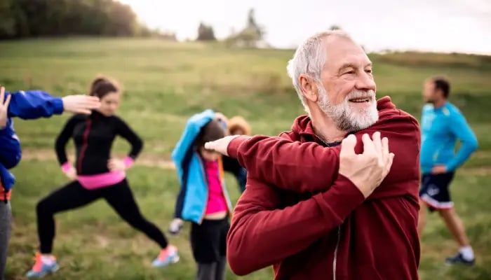Senior man joins an outdoor group fitness class