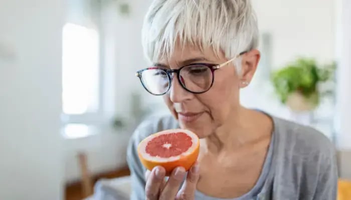 Mature woman smelling a grapefruit