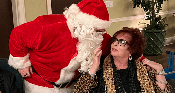 Senior woman hugging Santa Claus