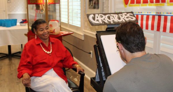 senior woman getting her portrait drawn 