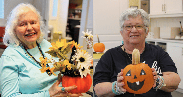 Two residents of The Bristal Assisted Living pose holding their festive fall pumpkin-themed artistic creations.