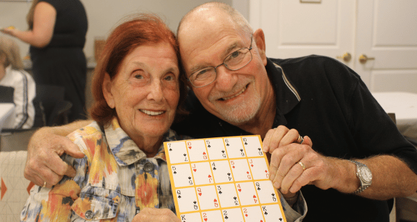 A resident of The Bristal at Lake Success poses with her son and their Pokeno card.