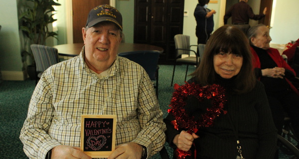senior couple holding valentine's day props