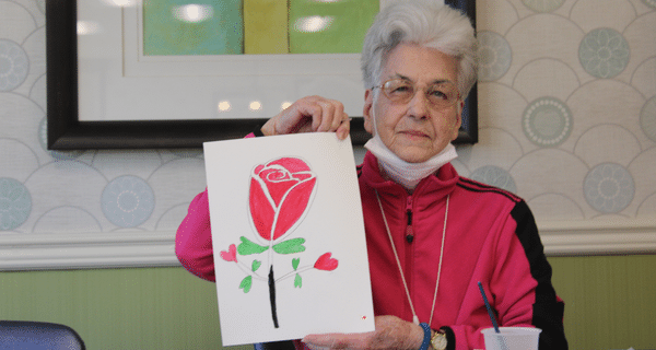 senior woman holding finished painting