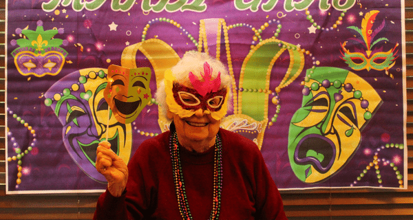 senior woman wearing mardi gras mask