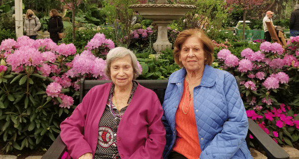 senior women seated in front of water fountain at flower show