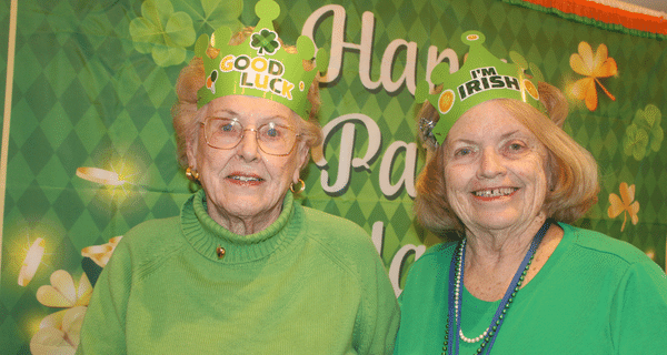 senior women wearing green and posing for photo together
