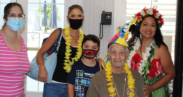 senior man and his family posing for photo with dancer