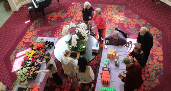 seniors and girl scouts in lobby with cookies and flowers