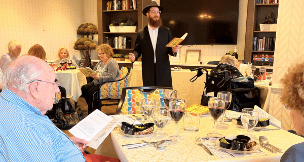rabbi leading residents through a passover seder
