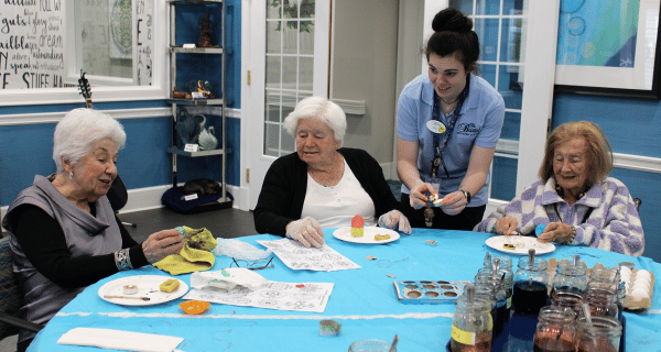 art therapist helping senior women make Ukrainian Easter eggs