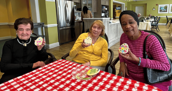 senior women holding easter cookies