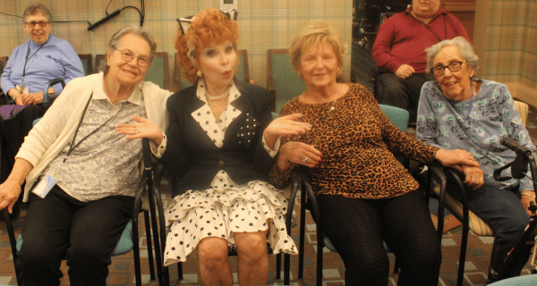 Lucille Ball impersonator seated with seniors