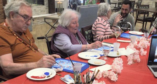 seniors seated at table painting