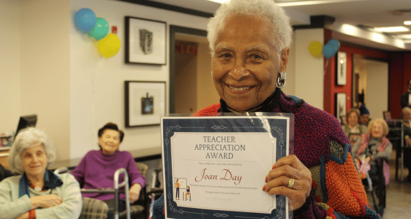 senior woman holding teacher appreciation certificate