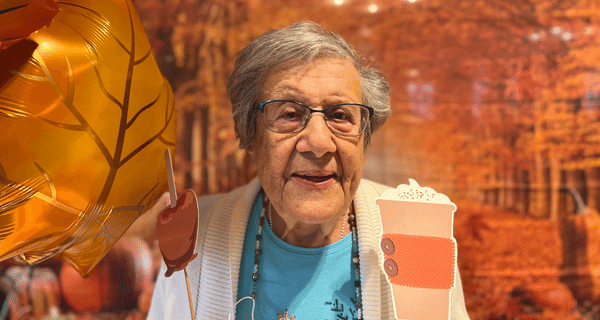 senior woman posing for photo with fall photo props