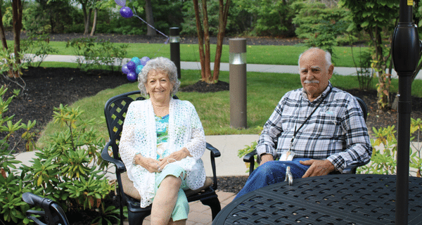 senior couple seated together at an outdoor table
