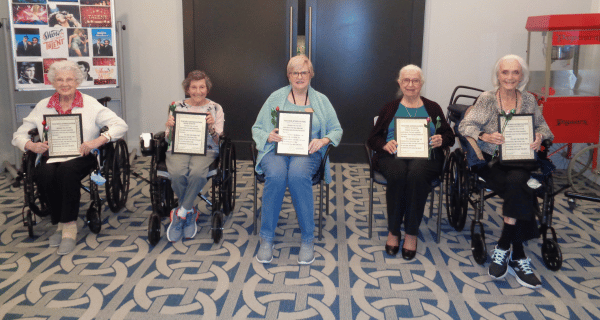 senior women holding teacher appreciation certificates