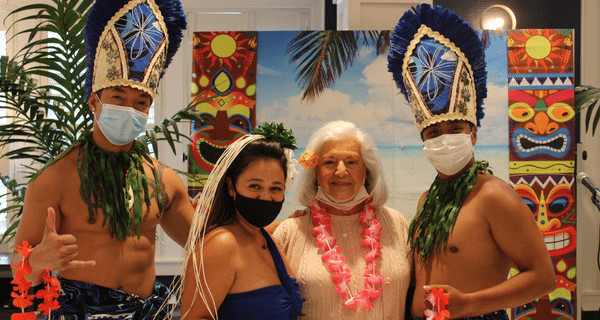 senior woman posing with polynesian dancers