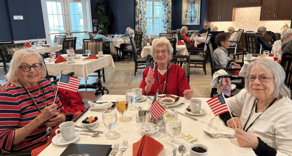 senior women seated at table holding flags