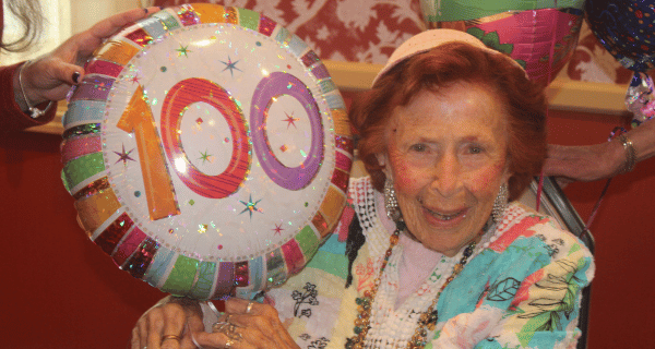 senior woman holding birthday balloons