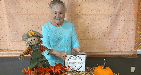 senior woman posing with fall photo props
