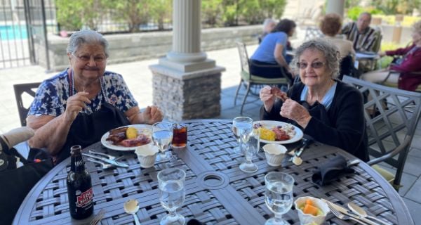 two senior women enjoying bbq lunch