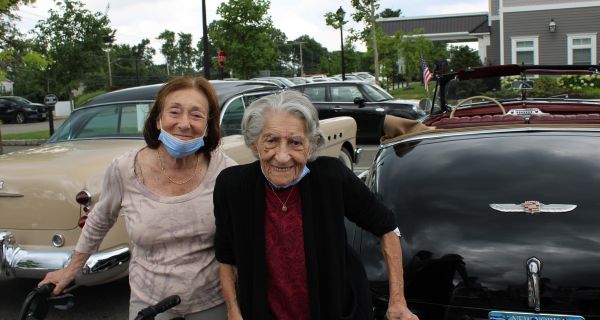 two senior women standing in front of classic cars at Jericho car show