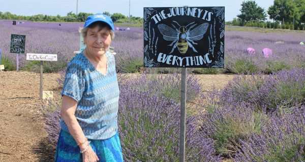 senior woman standing in front of lavender field