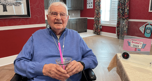 senior man holding milkshake