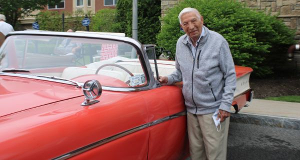 Senior man leaning against vintage automobile