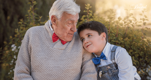 grandfather and grandson seated together on bench