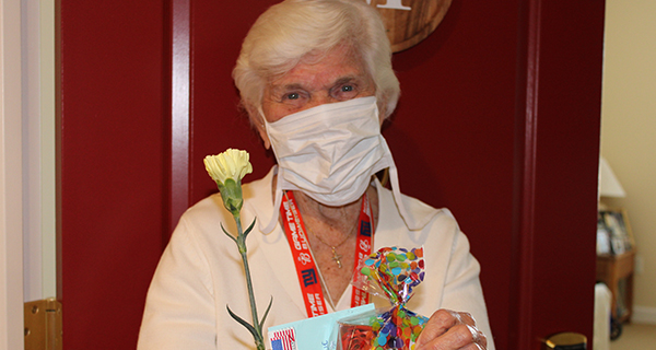 Resident holds a spa kit and carnation on Mother's Day