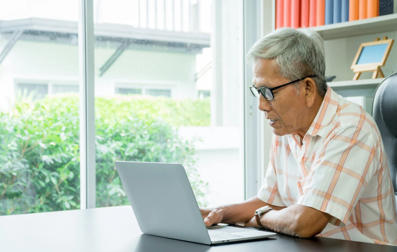 Older couple reviewing cost of senior living on a laptop computer in their home