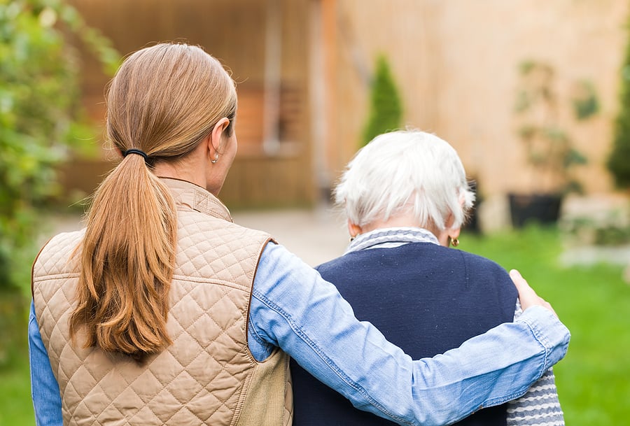Senior with dementia being helped by caregiver
