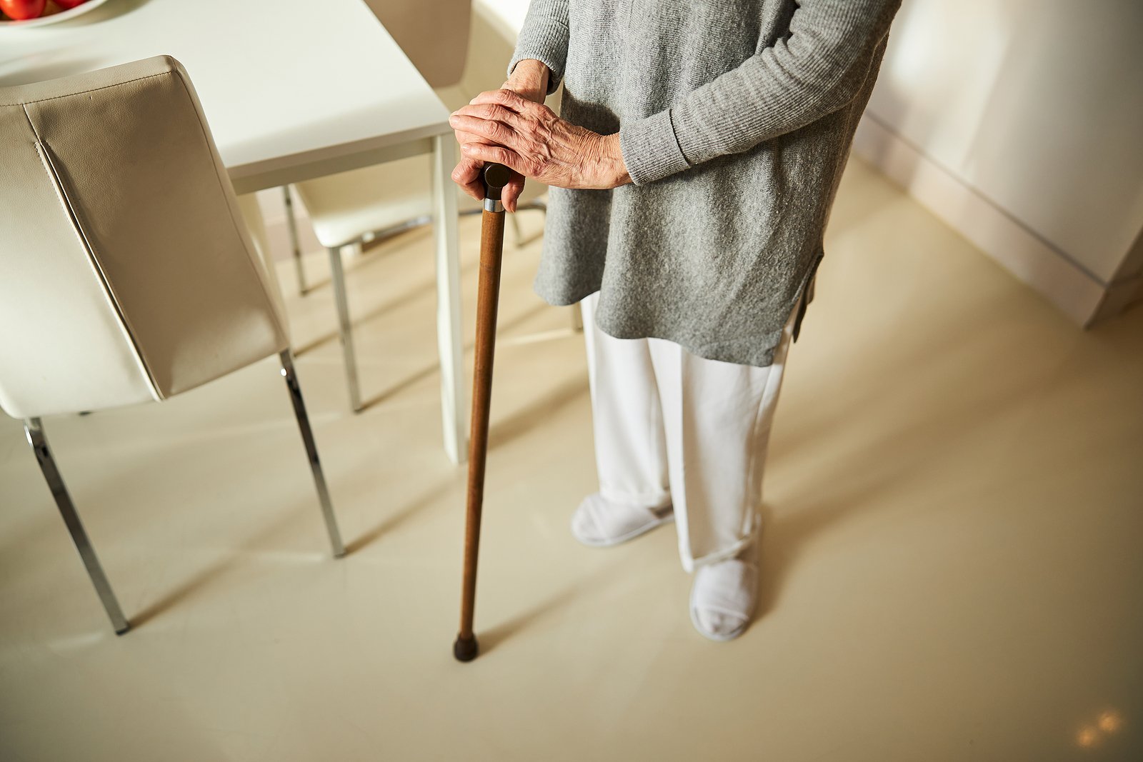 Senior holds cane in kitchen 