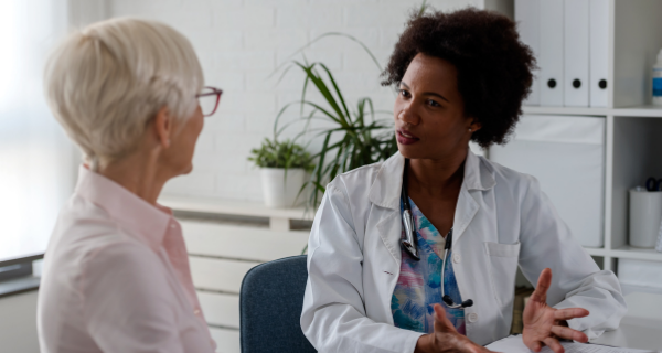 Female Alzheimer’s caregiver speaks with doctor