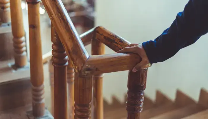 Person holding onto a stairs hand railing