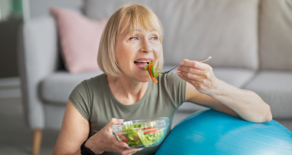 Fit and healthy senior woman eating a fresh vegetable salad