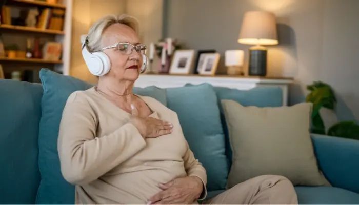 Senior woman practicing guided meditation at home