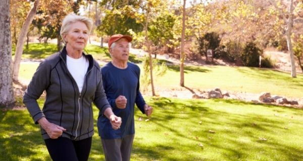 Senior couple walking together outdoors for exercise.
